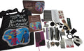 A flat lay of merchandise featuring a black tote bag and a brown notebook with 'Handbook for the Recently Deceased' cover art, alongside matching stationery, stickers, pens, and other accessories 